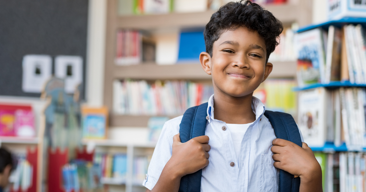 Kid at school with his backpack on 